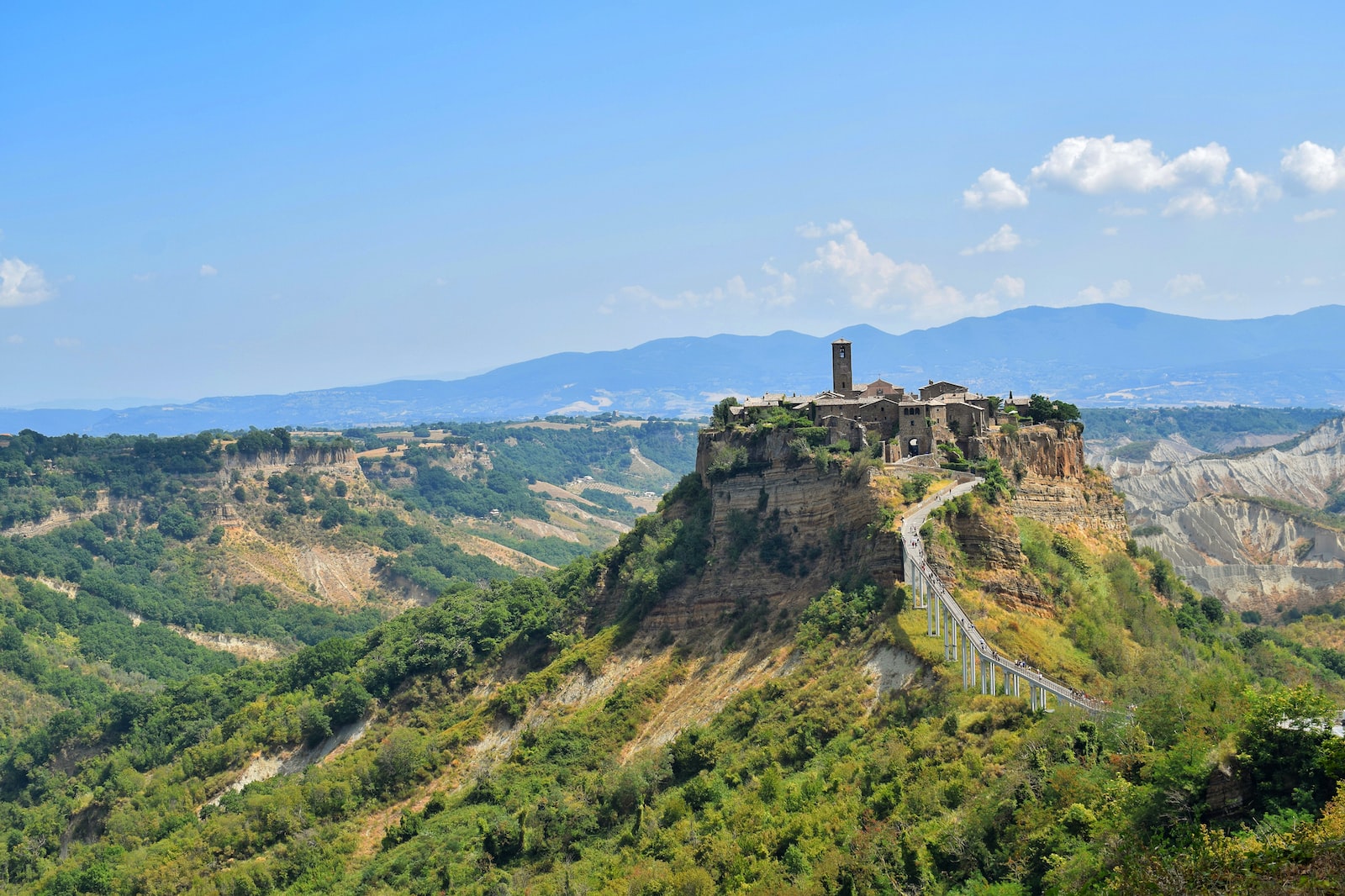Photo by Serena Ferracci green grass covered hill under blue sky during daytime